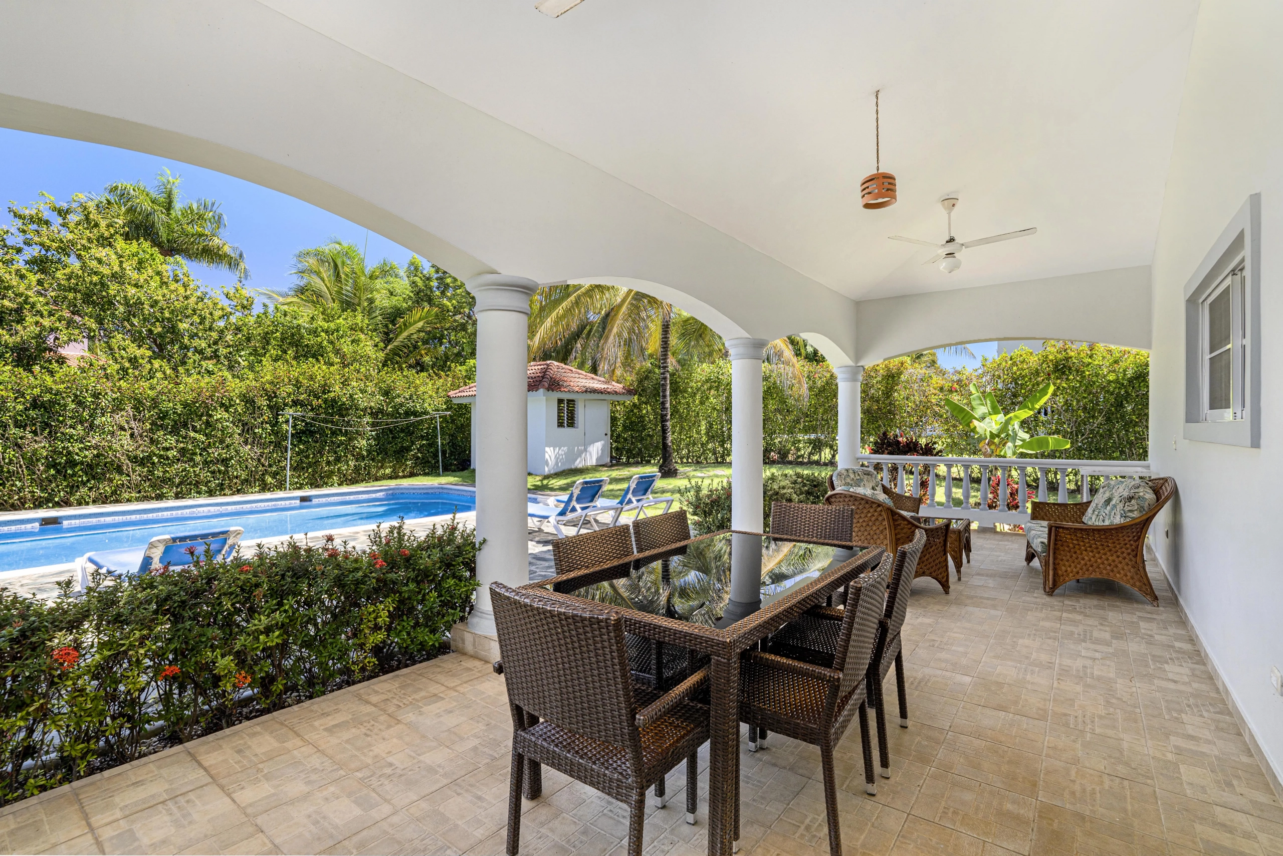 buyDRproperty Oversized patio with outdoor dining set overlooking a pool in a tropical villa. Sosua Real Estate