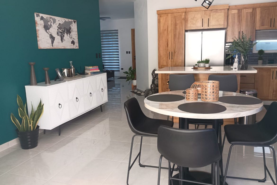 buyDRproperty Modern dining room with round table and black chairs in a Puerto Plata villa. Sosua Real Estate