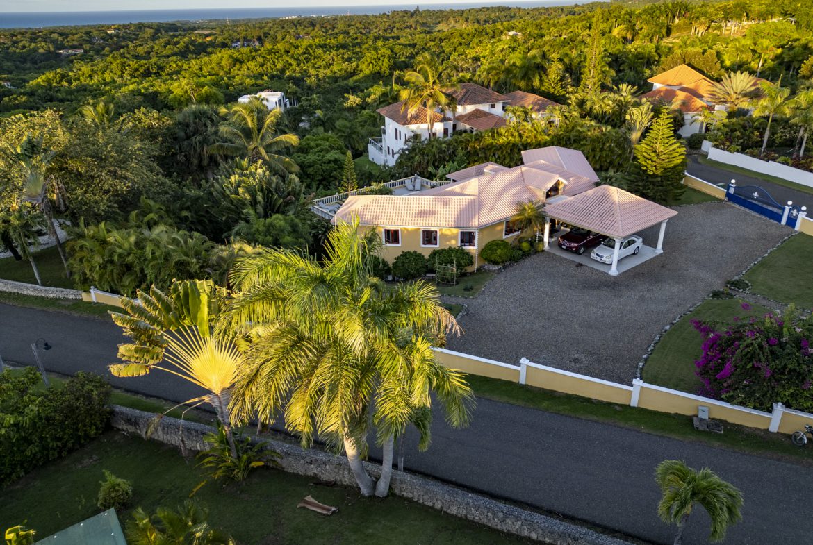 buyDRproperty Aerial view of a luxury villa for sale with ocean views in Panorama Village, surrounded by lush greenery. Sosua Real Estate