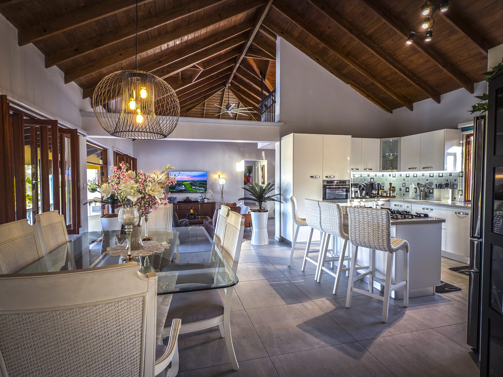 buyDRproperty Luxury villa interior with ocean views, featuring a dining area and modern kitchen. Sosua Real Estate
