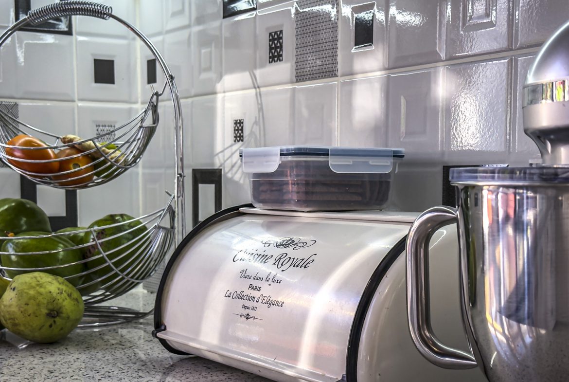 buyDRproperty Kitchen counter with fruit basket, bread box, and mixer, showcasing villa interior design. Sosua Real Estate