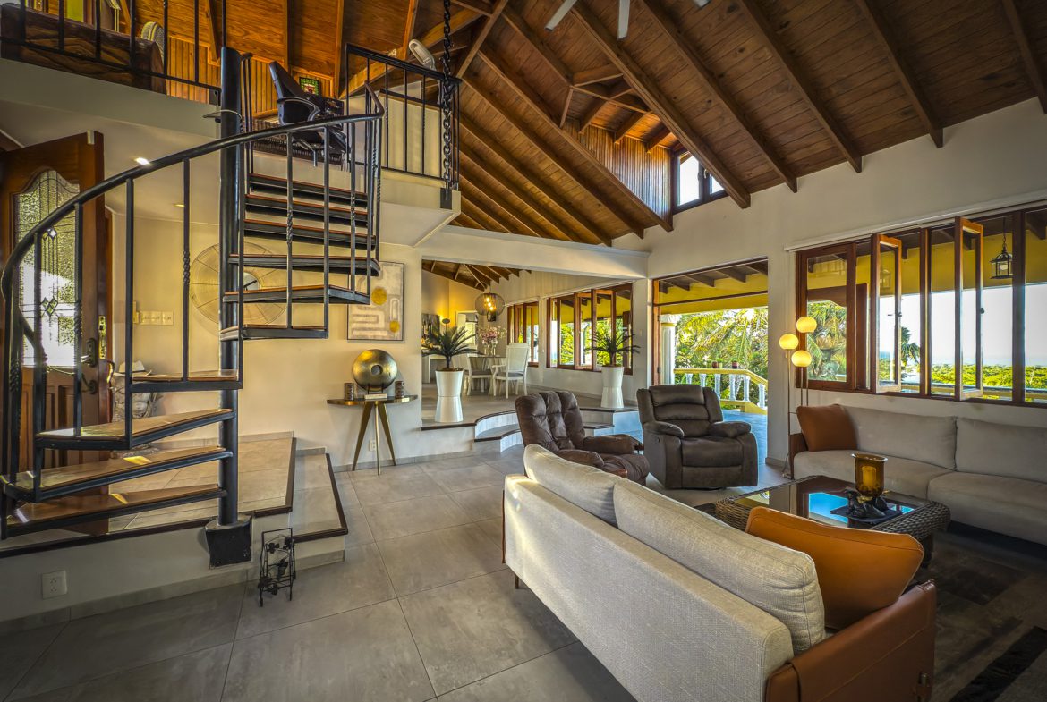 buyDRproperty Luxury villa interior with spiral staircase and ocean views. Villa for sale in Panorama Village. Sosua Real Estate