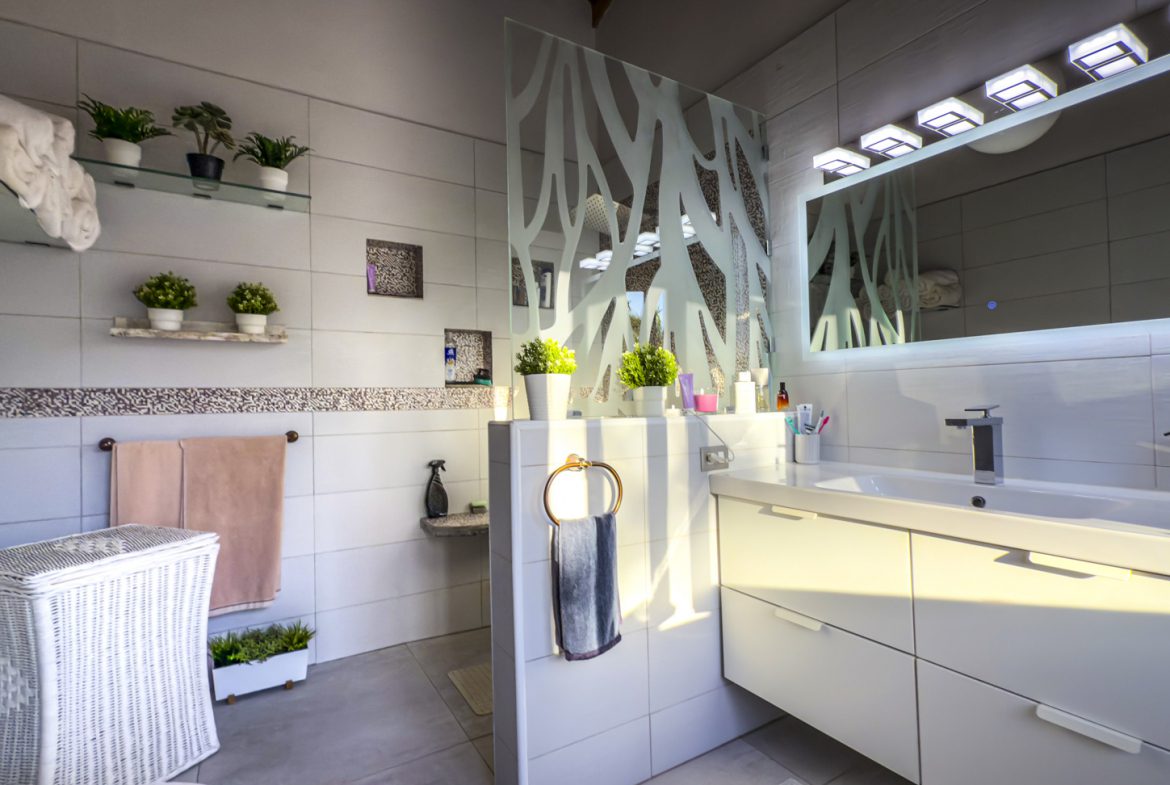 buyDRproperty Modern bathroom with ocean view villa style, white tiles, and decorative plants. Sosua Real Estate