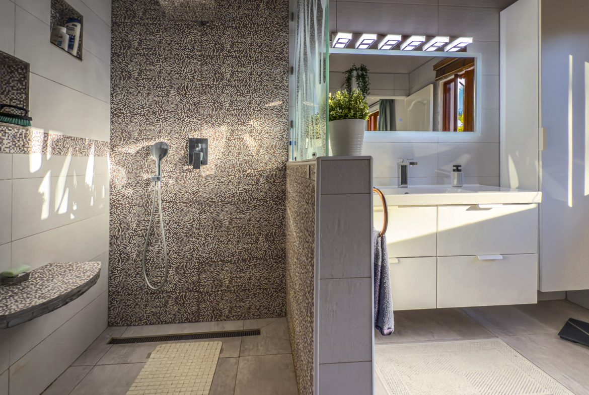 buyDRproperty Modern bathroom with walk-in shower and floating vanity, part of an Ocean View Villa. Sosua Real Estate