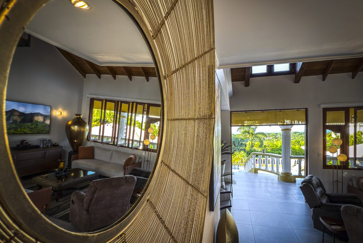 buyDRproperty Luxury villa interior reflected in a mirror showing living room with ocean views. Villa For Sale. Sosua Real Estate