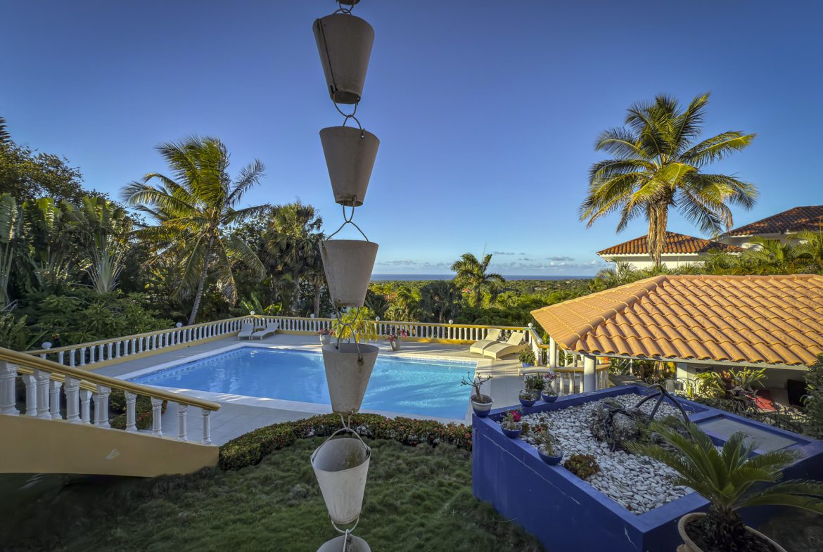buyDRproperty Luxury villa with ocean views, featuring a beautiful blue pool and palm trees in Panorama Village. Villa For Sale Sosua Real Estate