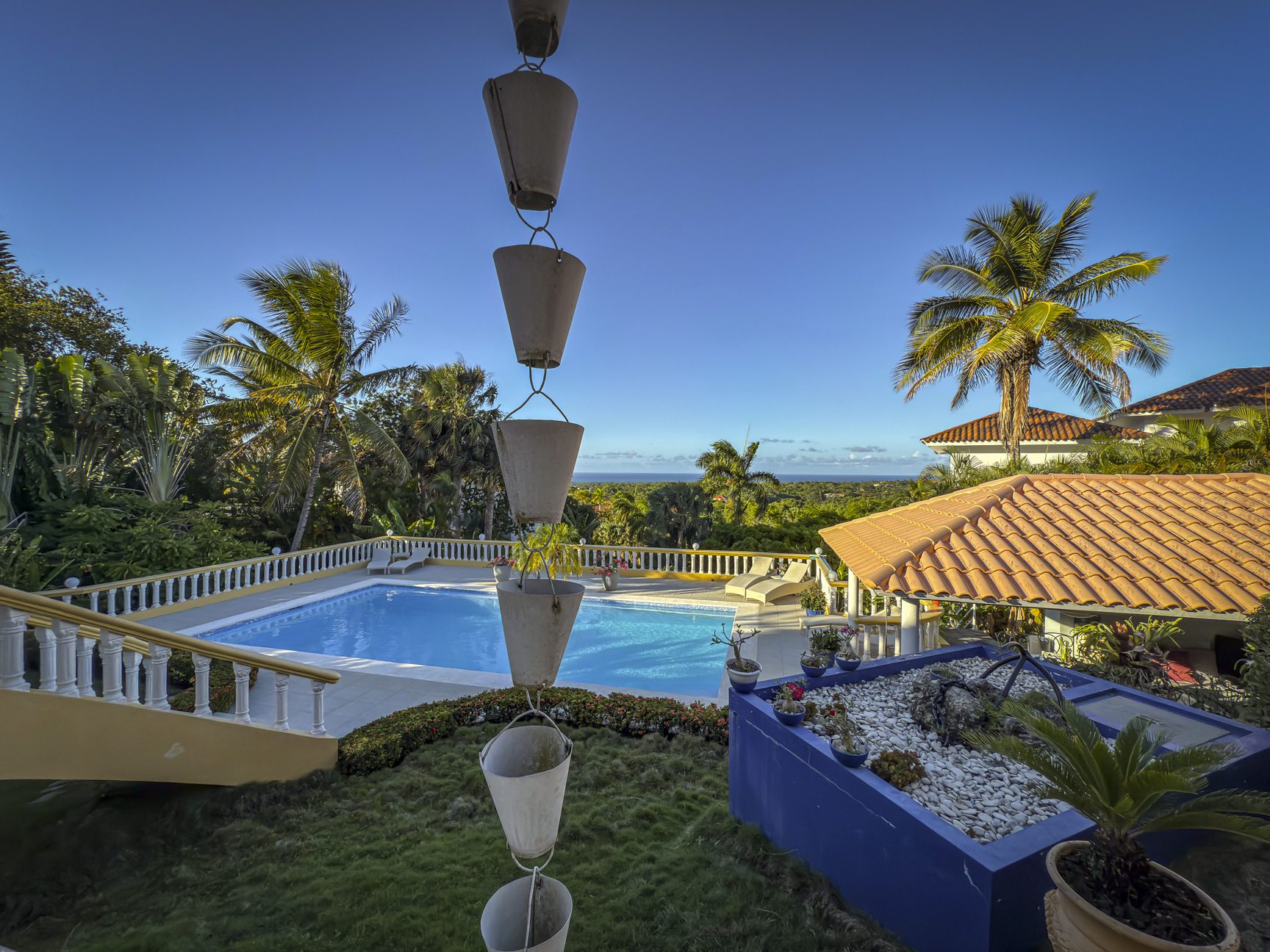 buyDRproperty Luxury villa with ocean views, featuring a beautiful blue pool and palm trees in Panorama Village. Villa For Sale Sosua Real Estate