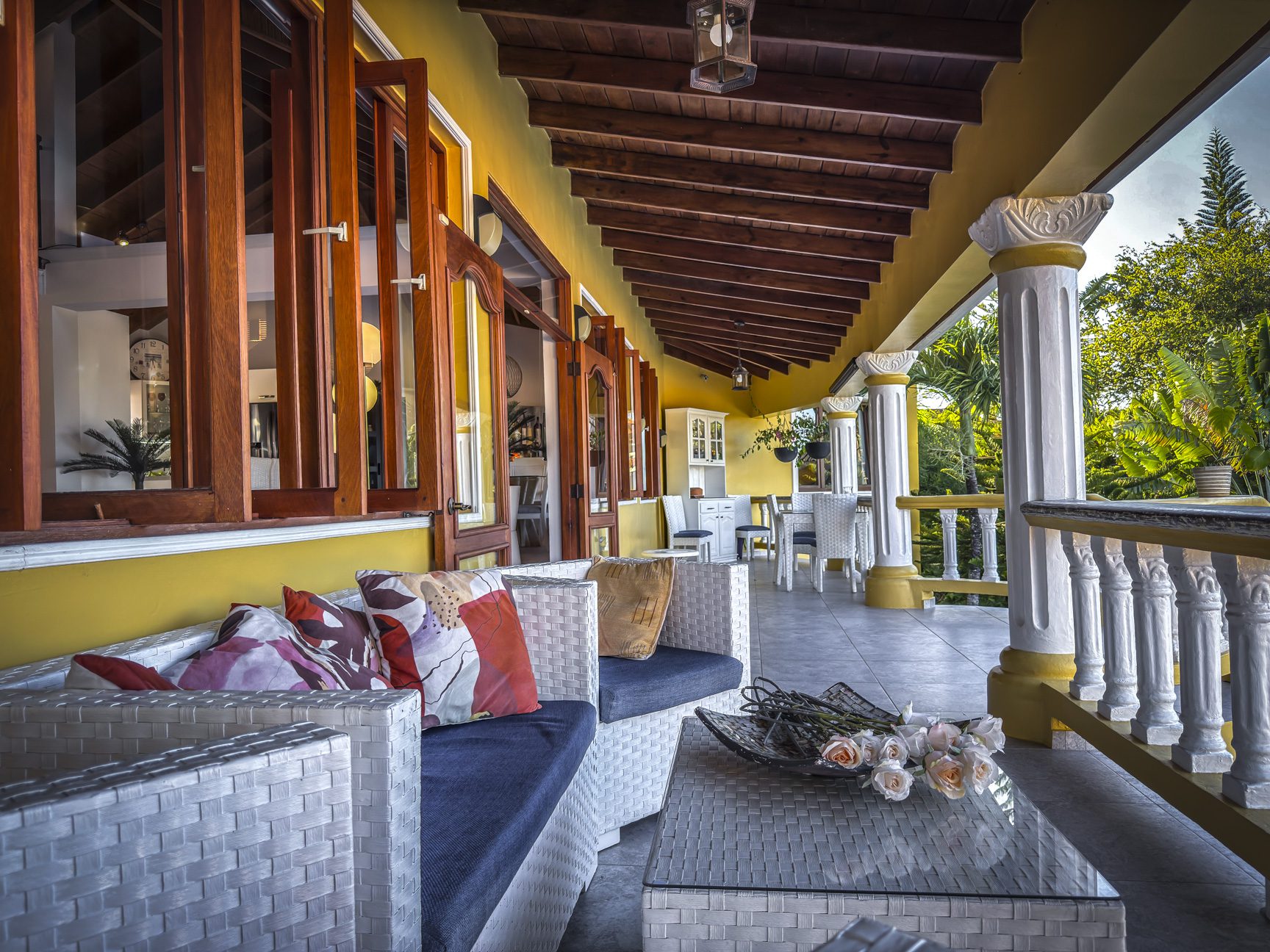buyDRproperty Luxury villa veranda with white wicker furniture and open windows. Enjoying ocean views from this villa for sale. Sosua Real Estate
