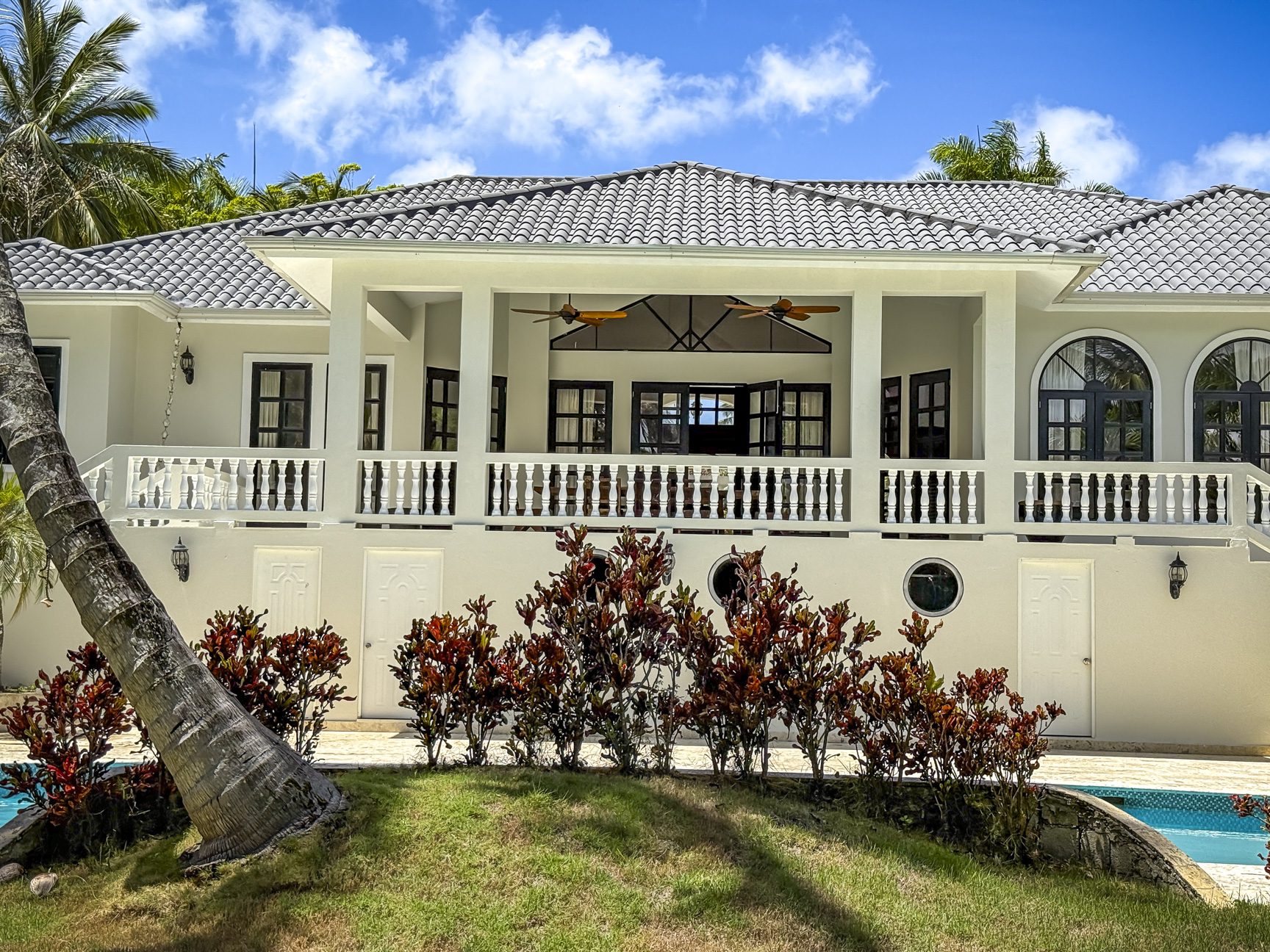 buyDRproperty Luxury villa in a tropical setting with a balcony, pool and palm trees. Sosua Real Estate