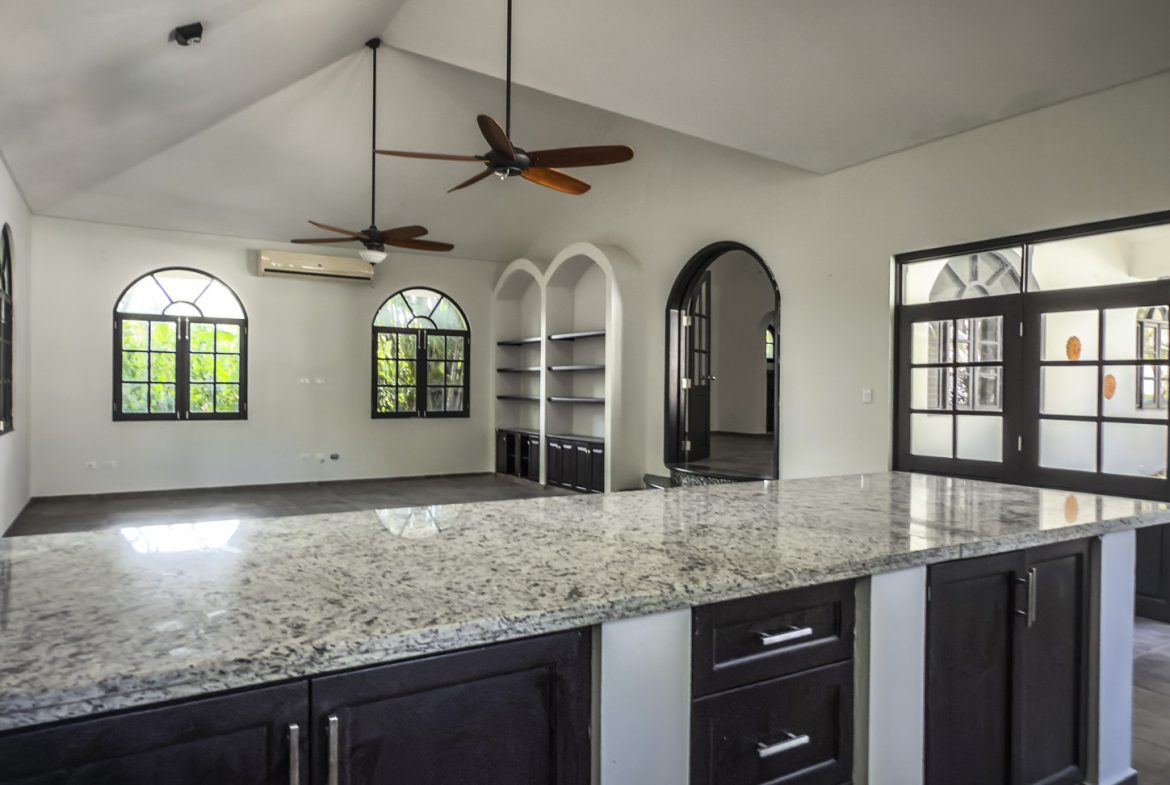 buyDRproperty Luxury home kitchen with granite countertop, open floor plan, and arched windows. Sosua Real Estate