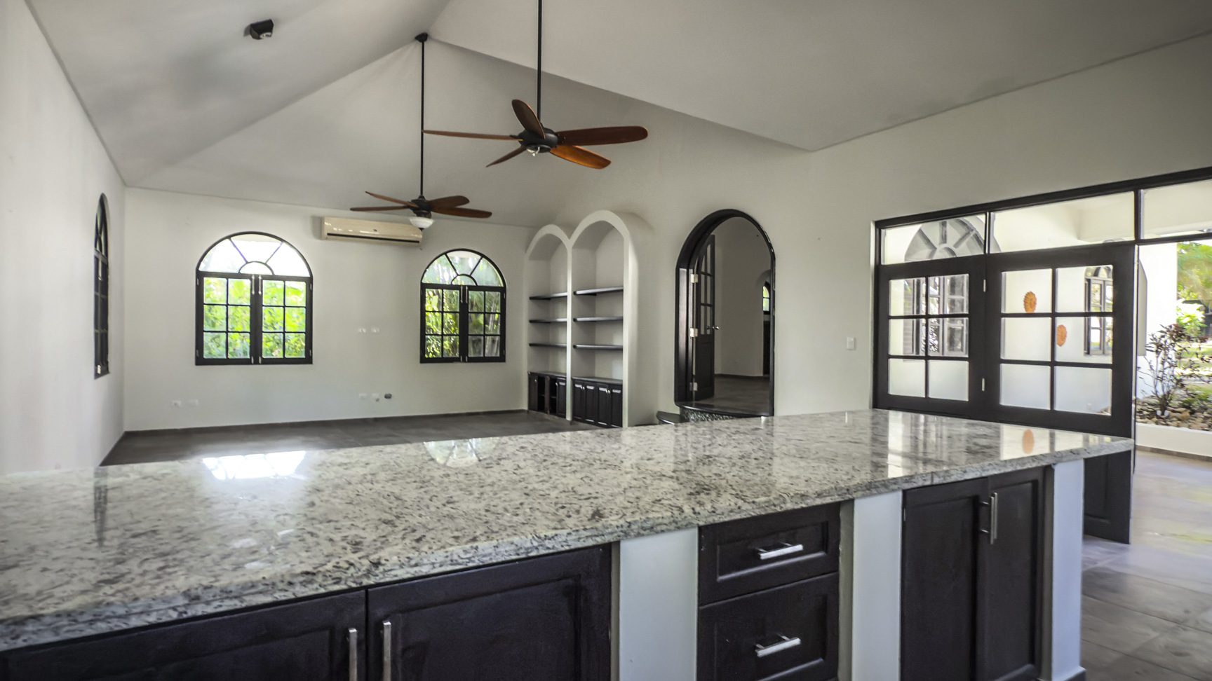 buyDRproperty Luxury home kitchen with granite countertop, open floor plan, and arched windows. Sosua Real Estate