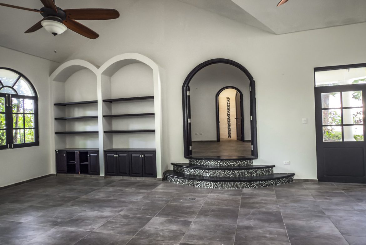 buyDRproperty Spacious modern home interior with arched doorway, built-in shelves, and tiled floor. Sosua Real Estate