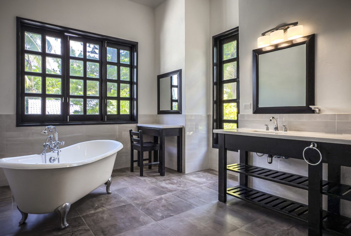 buyDRproperty Modern bathroom design with clawfoot tub, black vanity, and large window. Sosua Real Estate