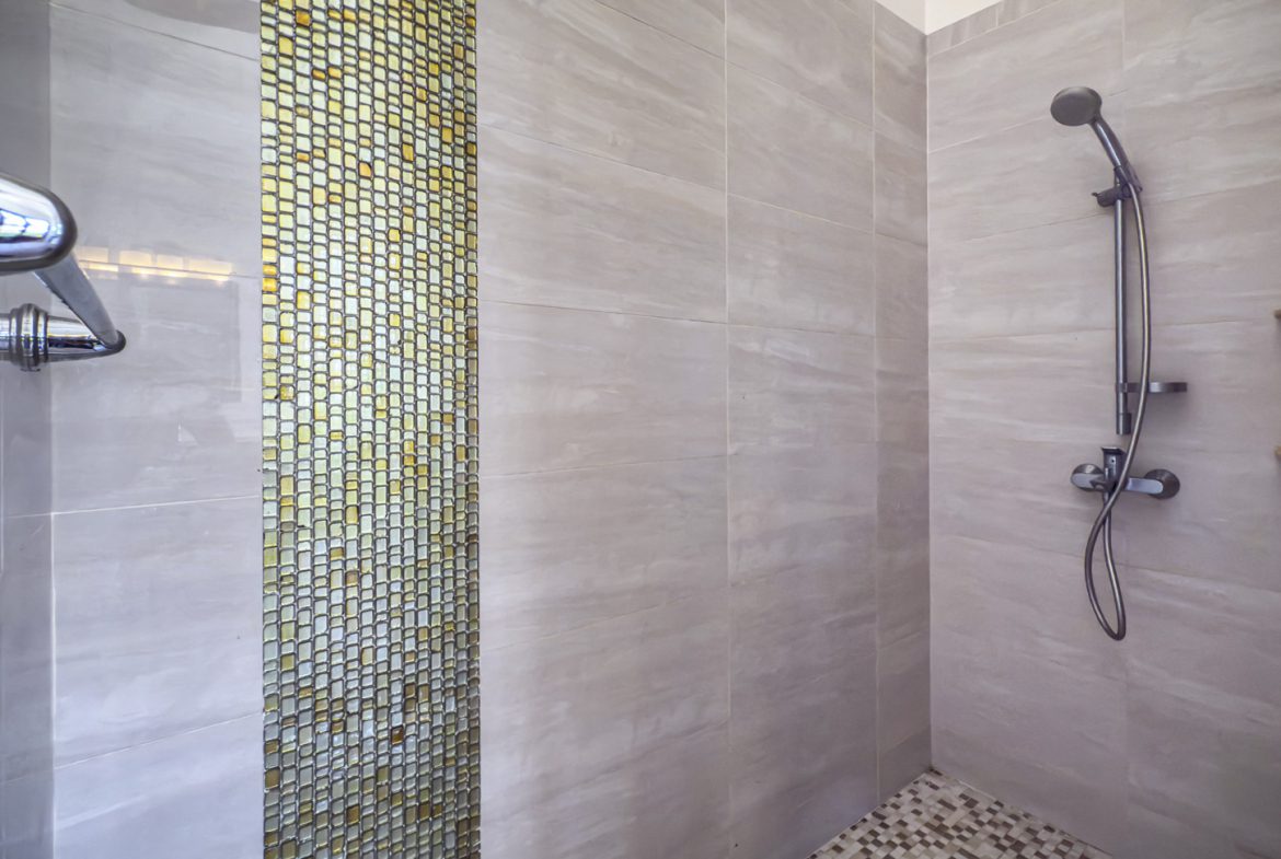buyDRproperty Modern shower design with light-colored tile and mosaic accent. Bathroom design inspiration. Sosua Real Estate