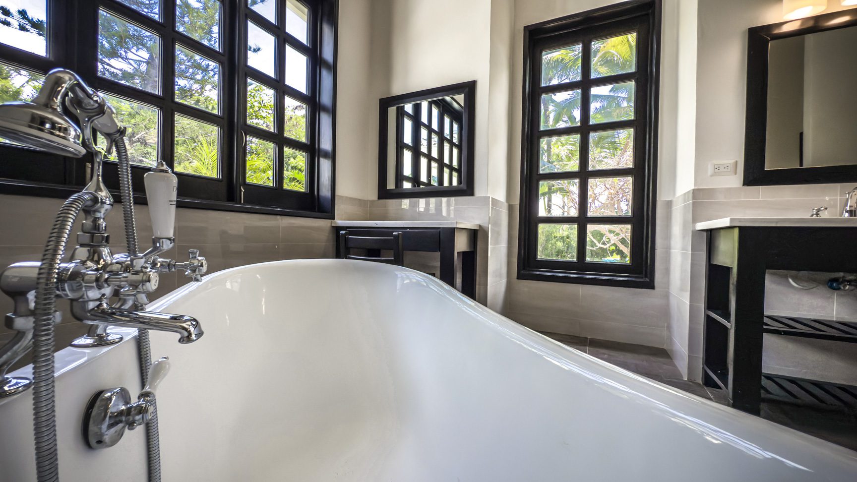 buyDRproperty Luxury bathroom with clawfoot tub, black framed windows, and spa-like ambiance. Sosua Real Estate