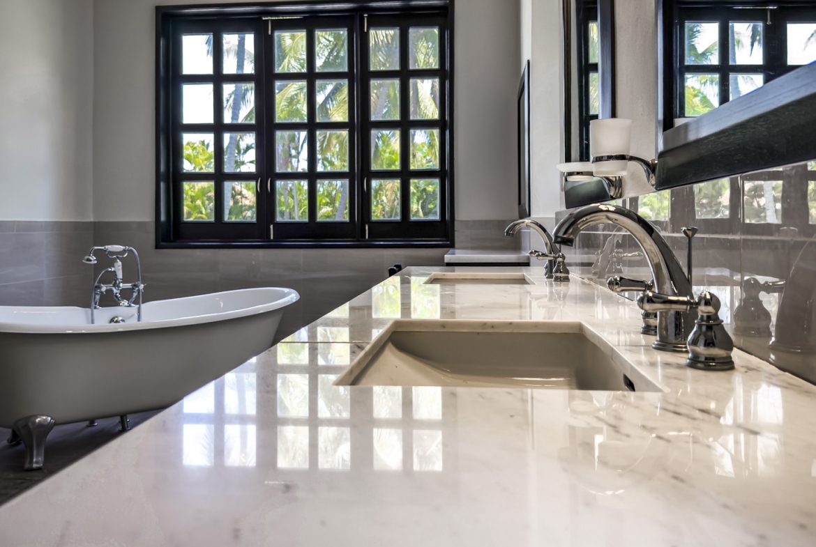 buyDRproperty Luxury bathroom with clawfoot tub, marble vanity, and large window Sosua Real Estate
