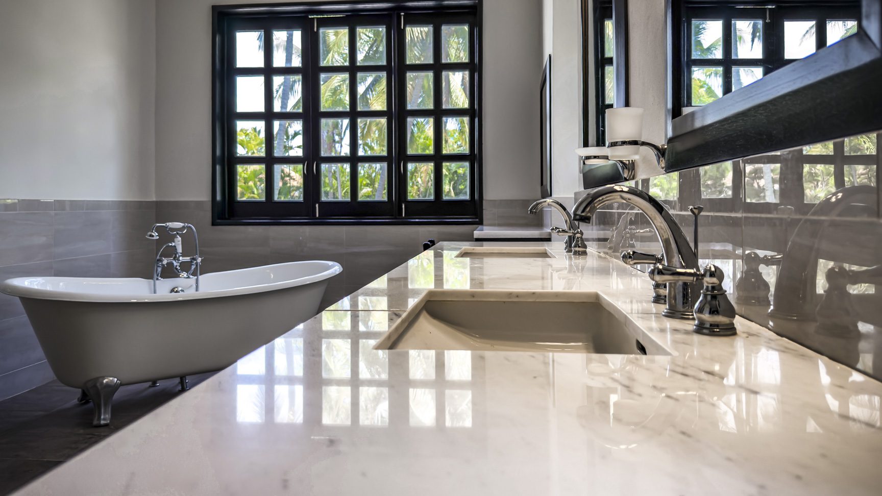 buyDRproperty Luxury bathroom with clawfoot tub, marble vanity, and large window Sosua Real Estate