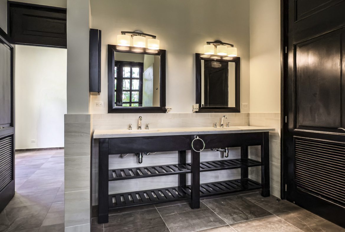 buyDRproperty Luxury bathroom with double vanity, dark wood, and modern lighting. Sosua Real Estate