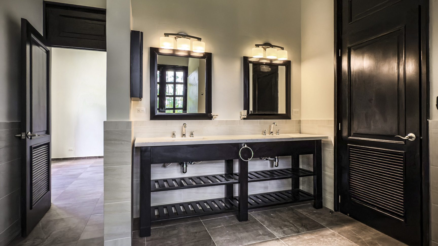 buyDRproperty Luxury bathroom with double vanity, dark wood, and modern lighting. Sosua Real Estate