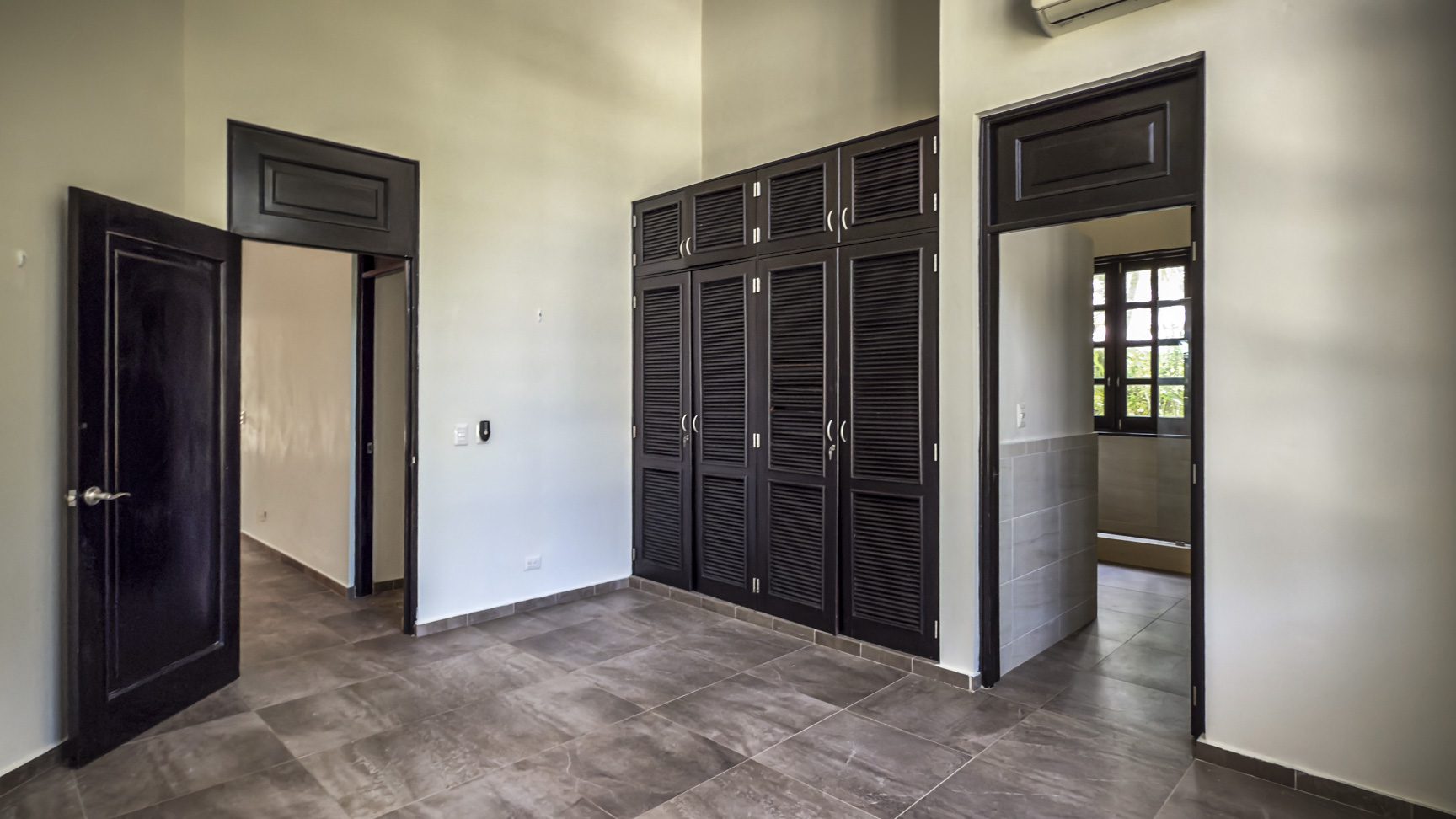 buyDRproperty Modern bedroom with dark wood closet and doors Sosua Real Estate