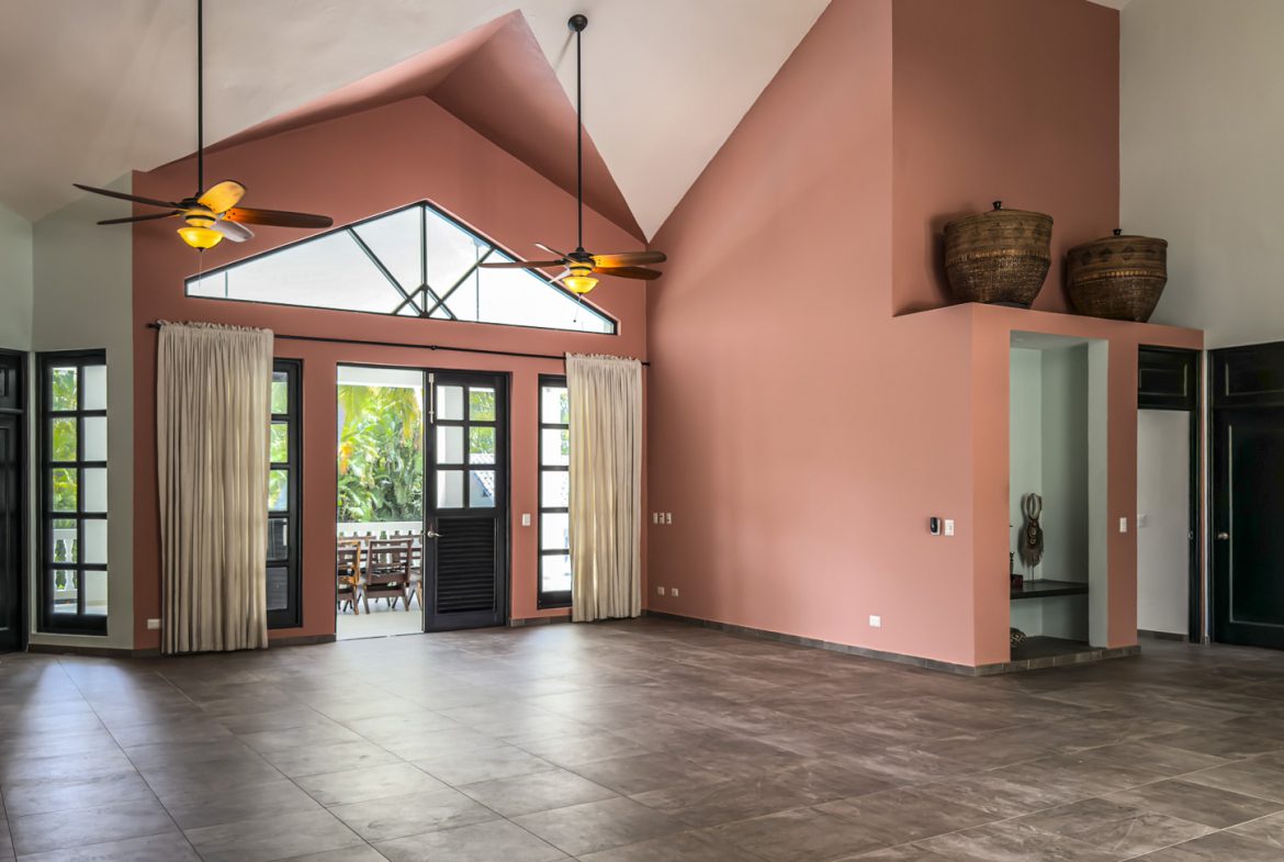 buyDRproperty Spacious open concept living room with high ceilings, modern architecture, and terracotta walls Sosua Real Estate