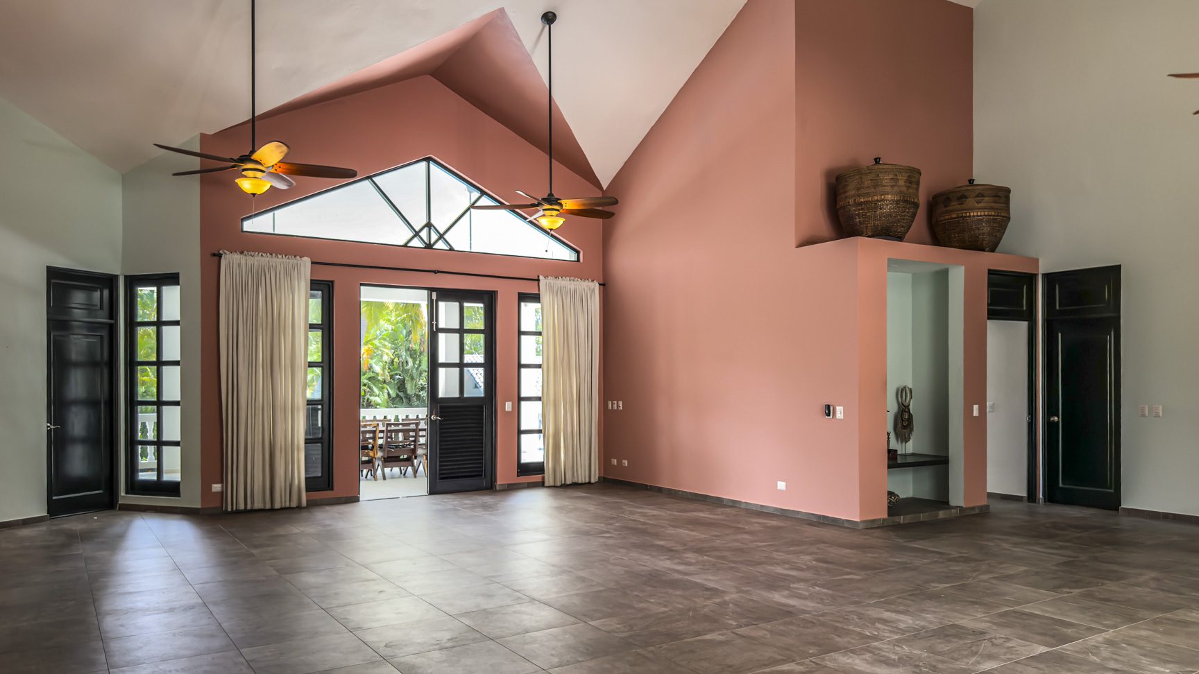 buyDRproperty Spacious open concept living room with high ceilings, modern architecture, and terracotta walls Sosua Real Estate