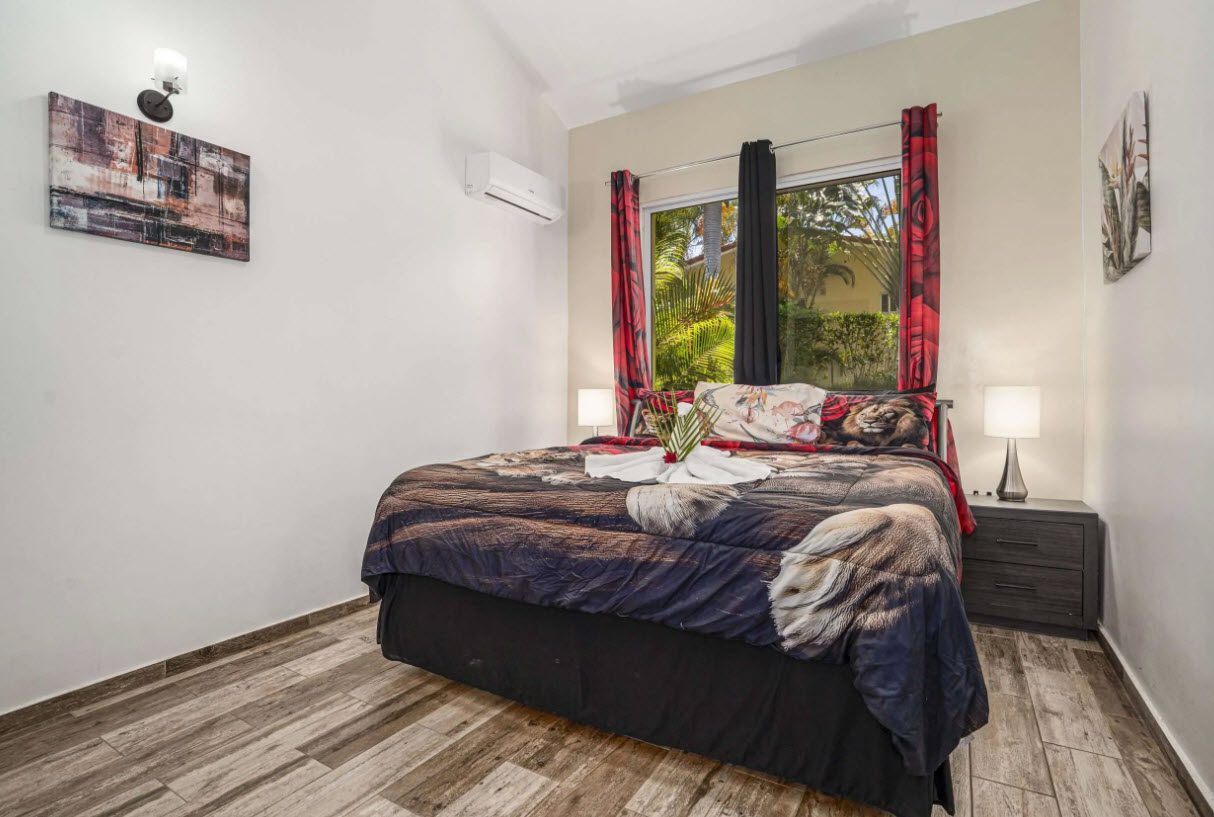 buyDRproperty Elegant bedroom in Villa Lotus with a king-sized bed and red curtains. Sosua Real Estate