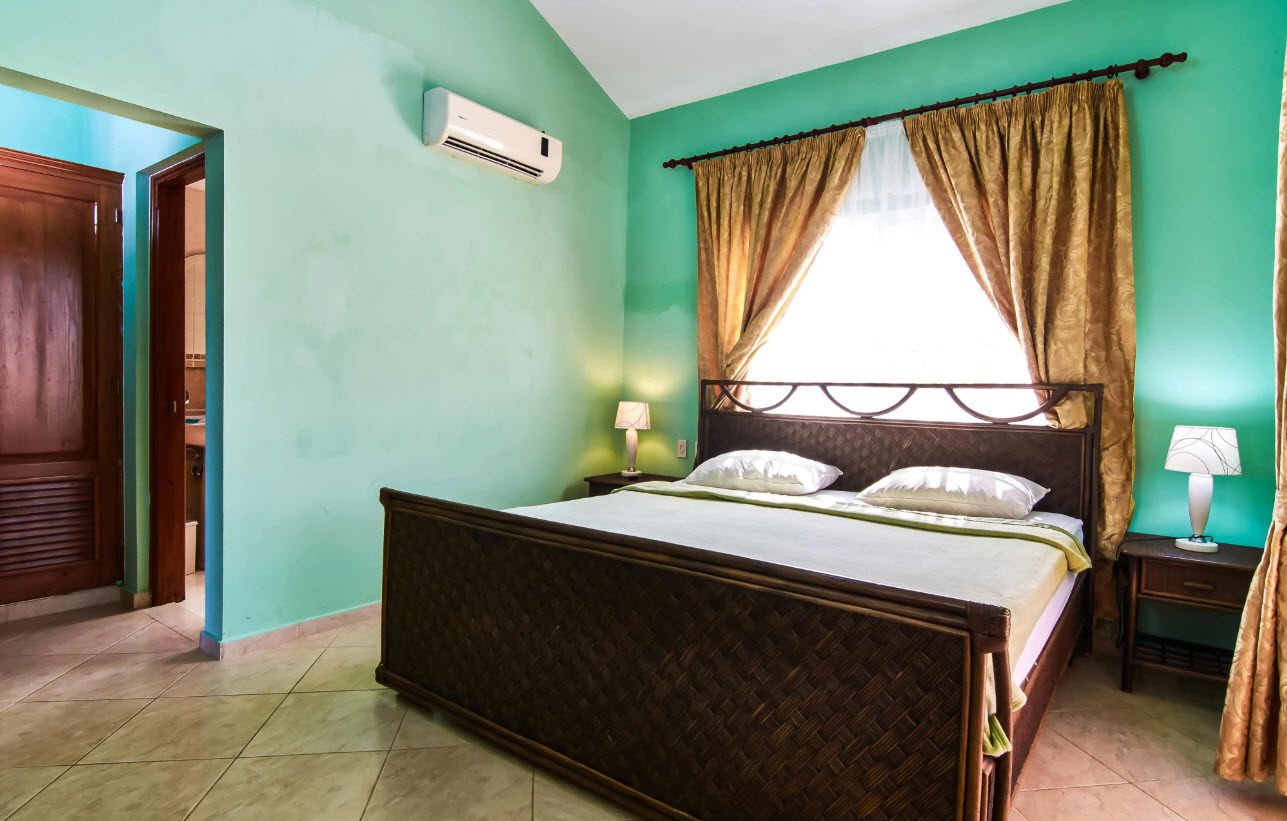 buyDRproperty Bedroom with a large bed, curtains, and an air conditioner in a Residential Hispaniola villa. Sosua Real Estate