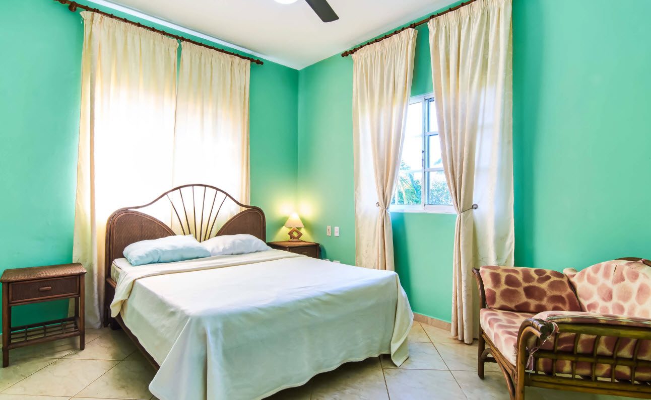buyDRproperty Bedroom in a villa for sale in Residential Hispaniola with a bed, window, and sofa. Sosua Real Estate