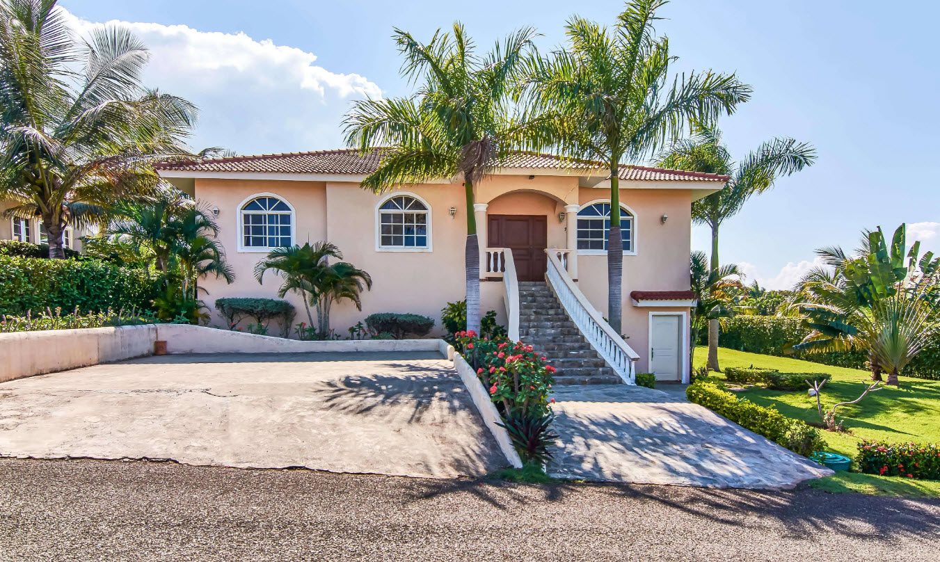 buyDRproperty Luxury villa for sale in Residential Hispaniola with palm trees and driveway Sosua Real Estate