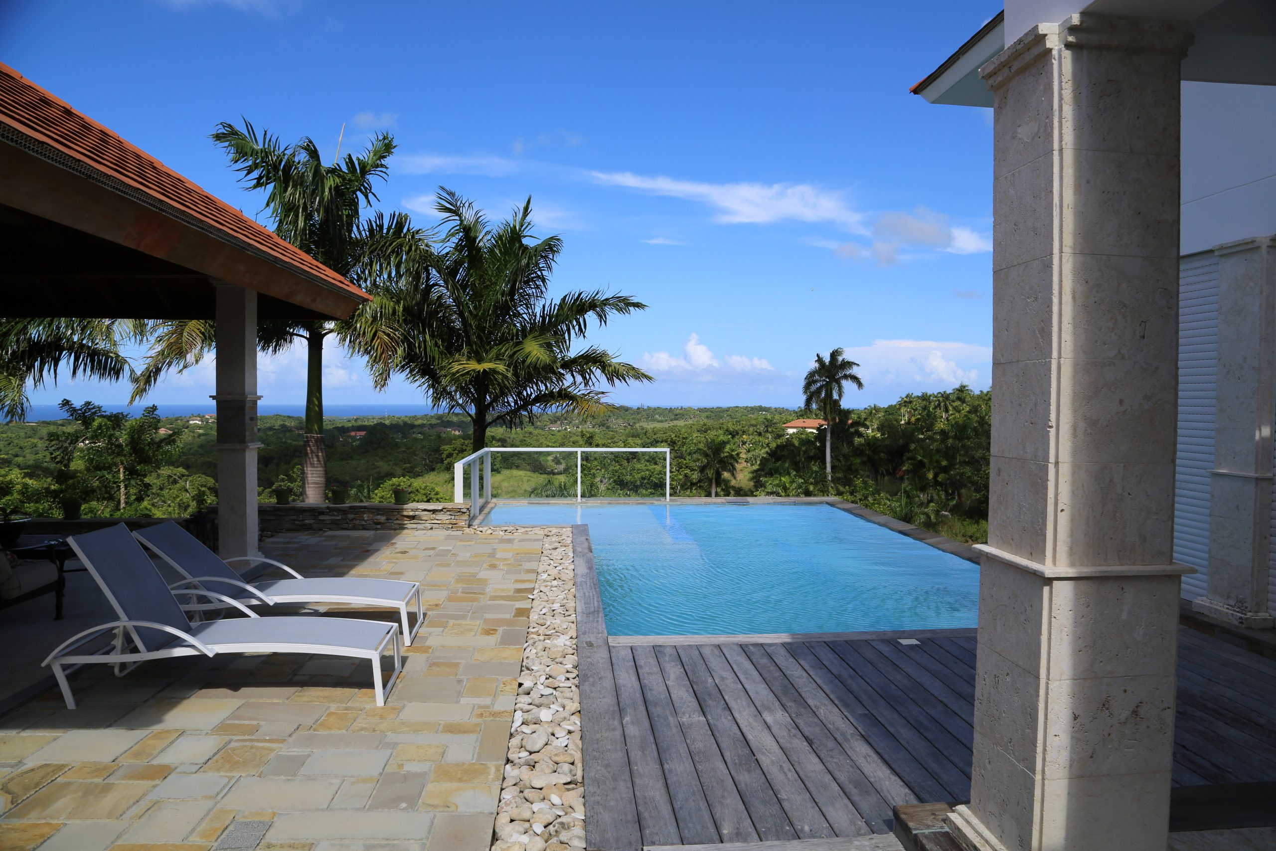 buyDRproperty Infinity pool with lounge chairs overlooking tropical landscape Sosua Real Estate