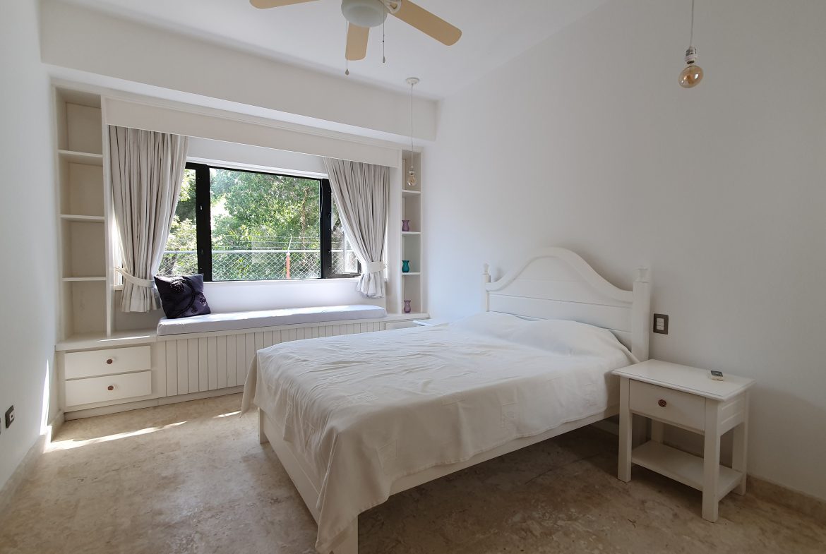 buyDRproperty Cozy white bedroom with window seat, bed, and natural light. Sosua Real Estate