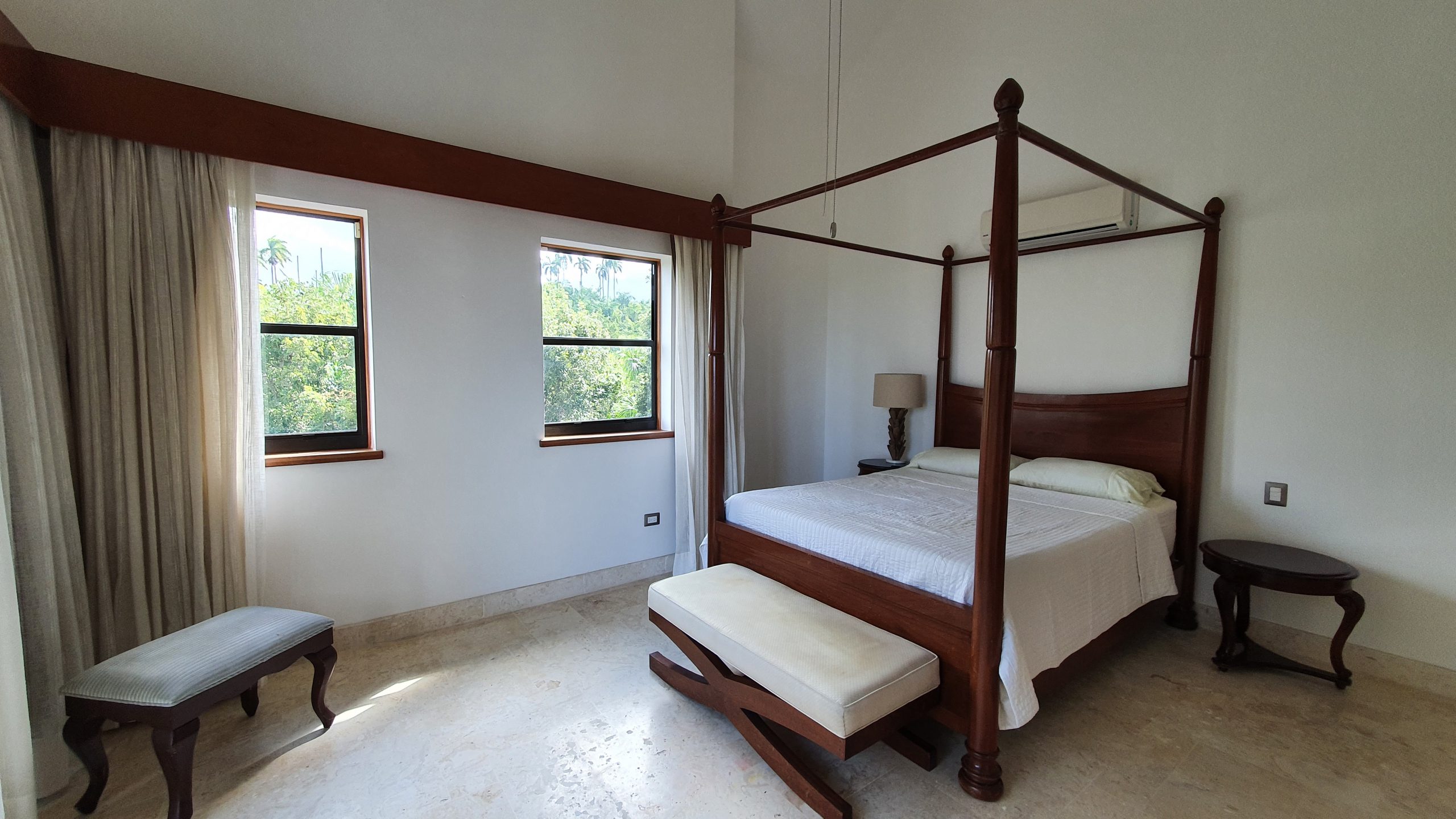 buyDRproperty Luxury bedroom with a dark wood four-poster bed, bench, and side table. Bedroom design. Sosua Real Estate