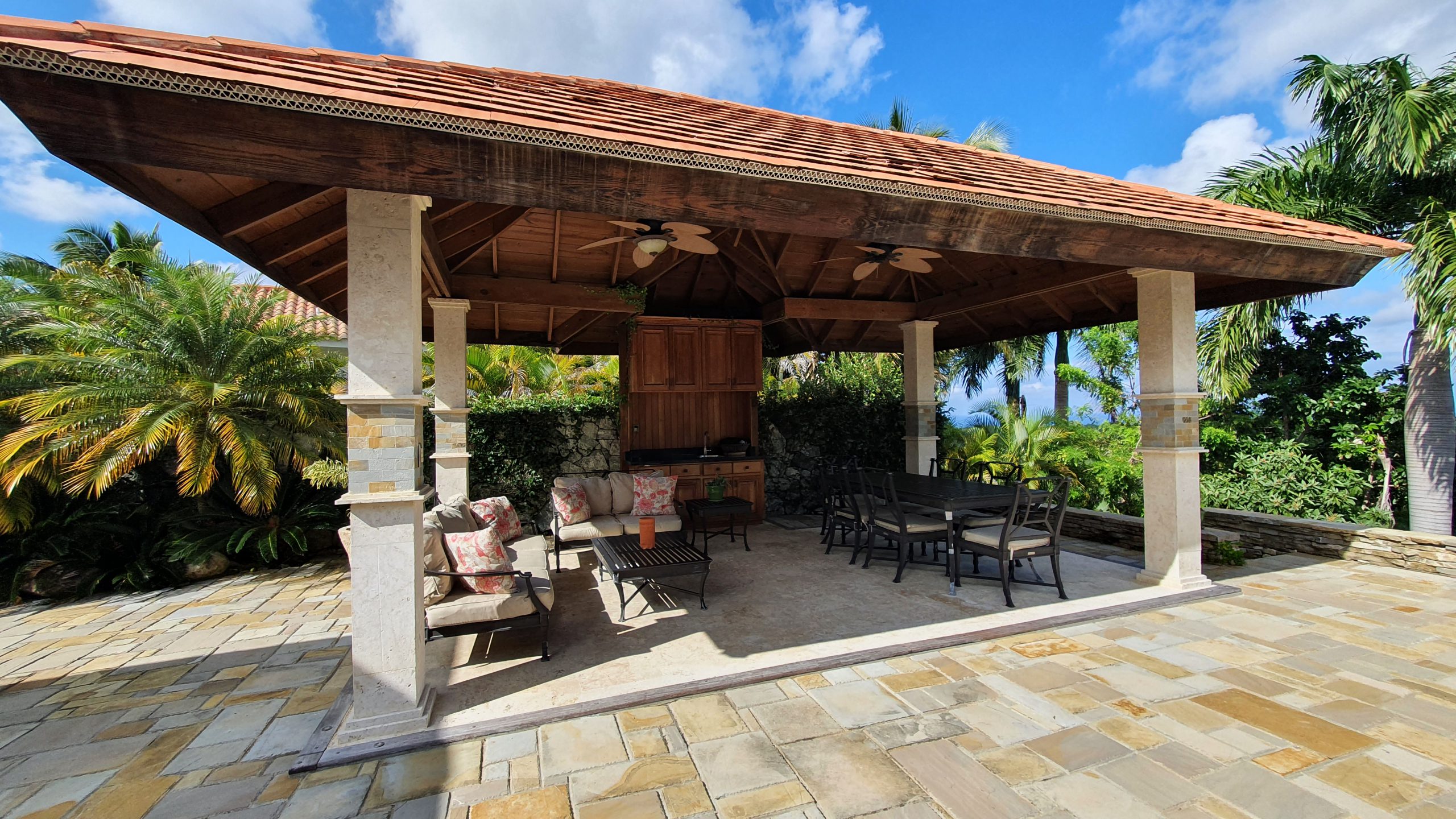 buyDRproperty Luxurious outdoor patio with gazebo, seating area, and dining table in a luxury home. Sosua Real Estate
