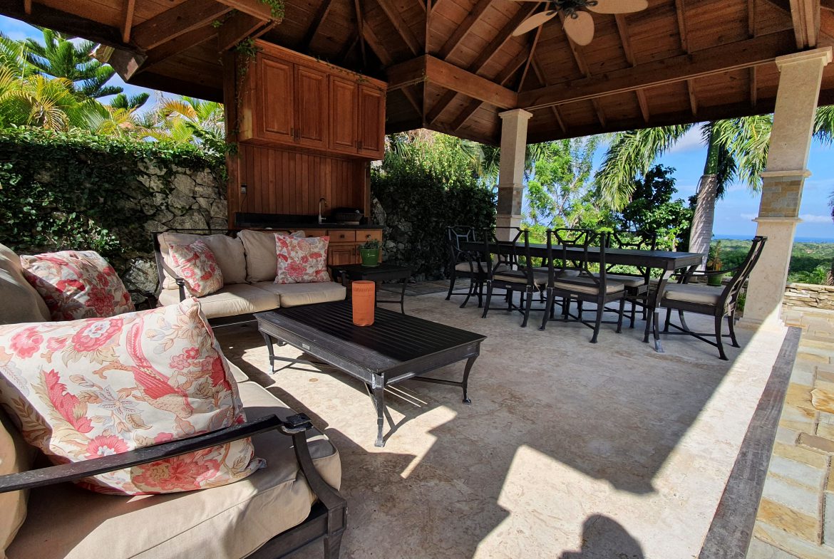buyDRproperty Covered patio with outdoor seating, dining table, and lush greenery. Perfect for patio design and outdoor living. Sosua Real Estate