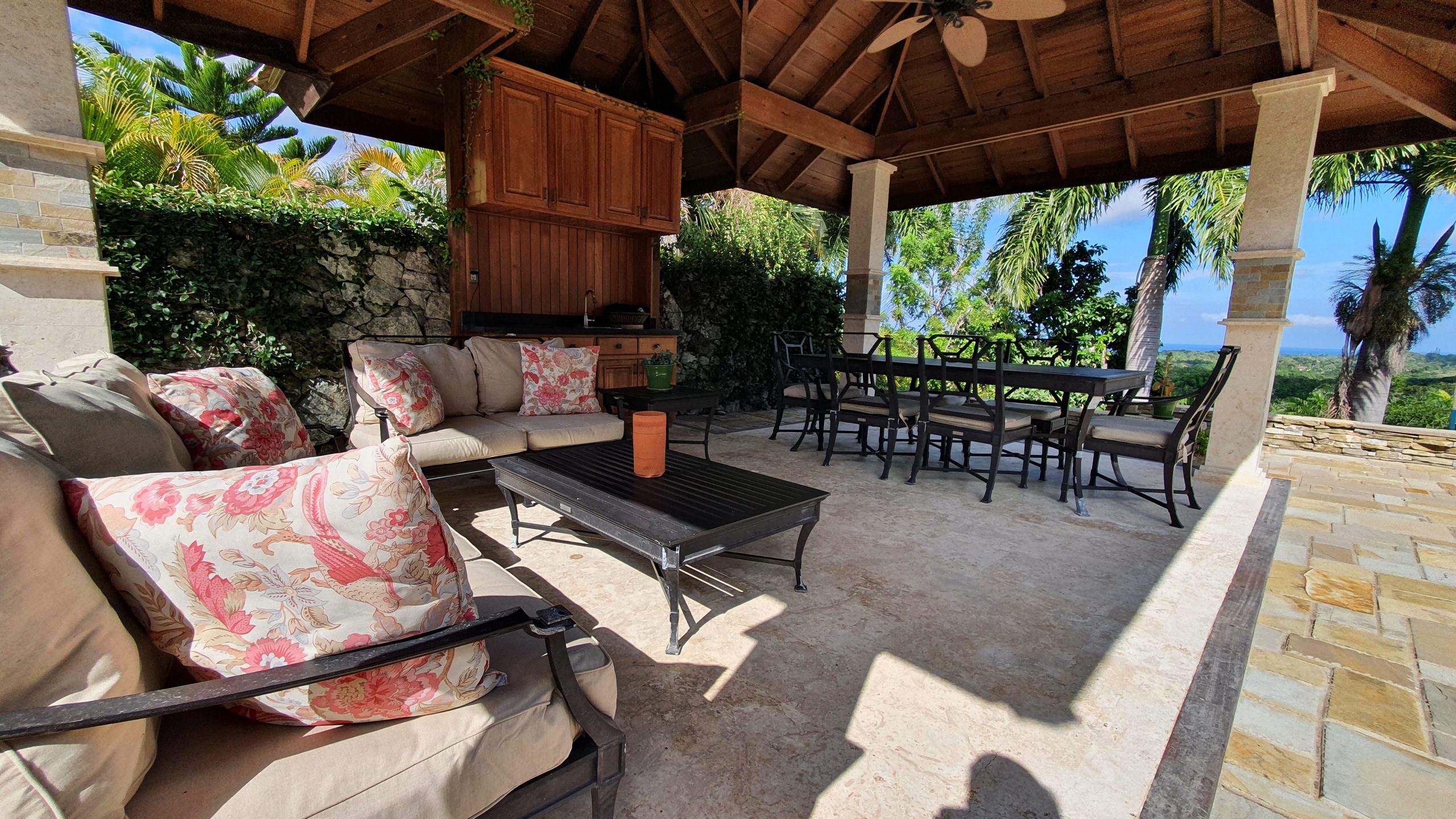 buyDRproperty Covered patio with outdoor seating, dining table, and lush greenery. Perfect for patio design and outdoor living. Sosua Real Estate