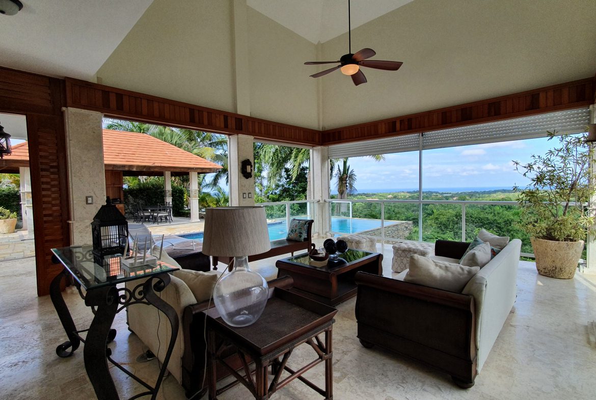 buyDRproperty Luxury home living room with ocean view, pool, and comfortable seating. Sosua Real Estate