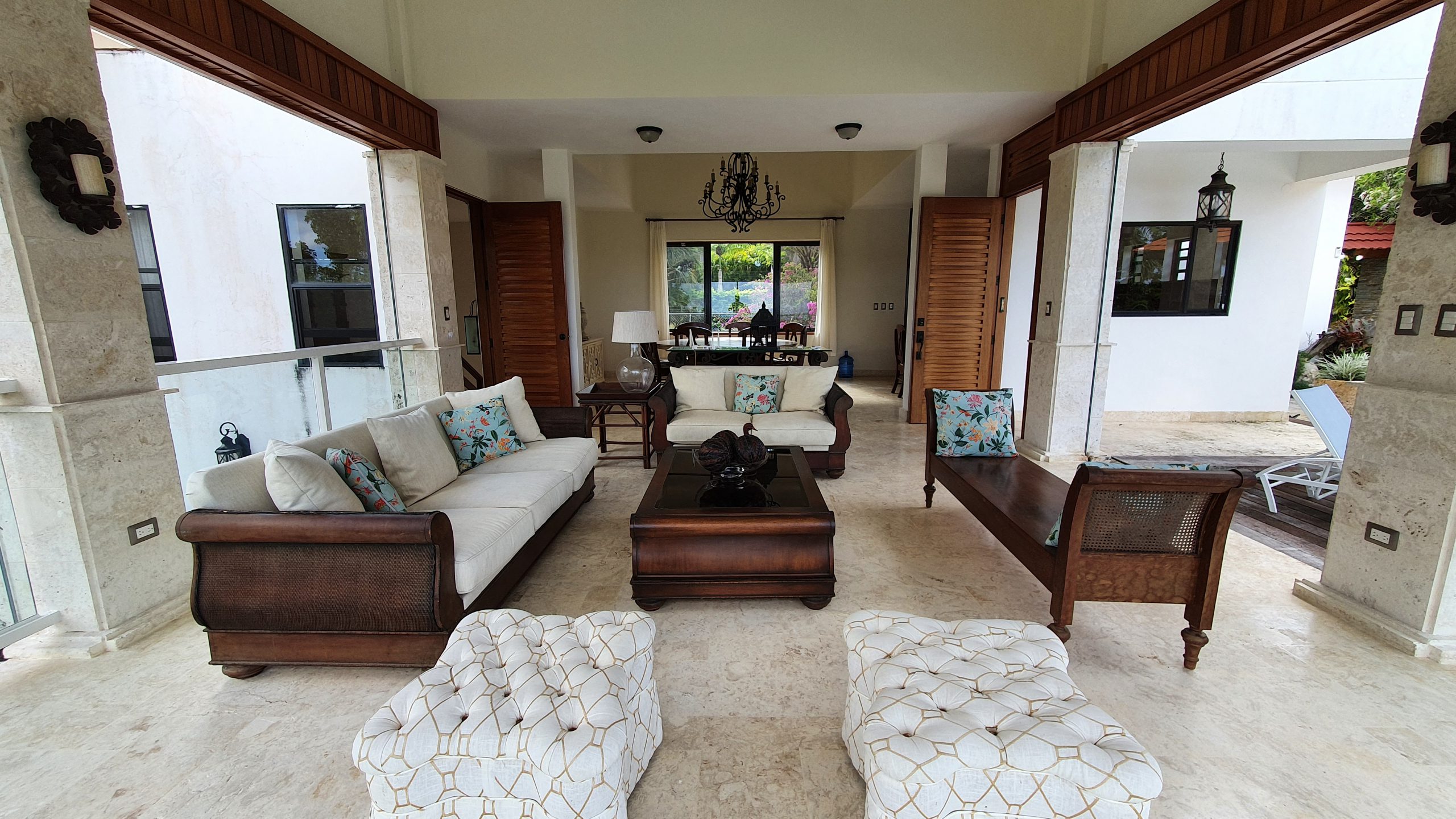 buyDRproperty Luxury outdoor living room with white sofas, wooden furniture, and patio design Sosua Real Estate