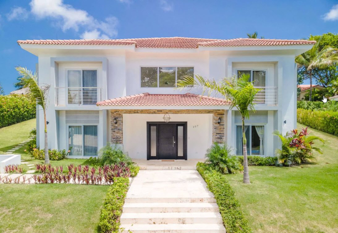 buyDRproperty Luxury two-story villa with a red tile roof and manicured lawn. Sosua Real Estate