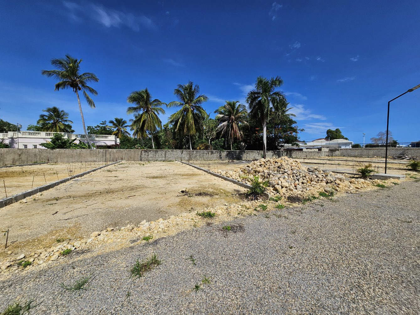 buyDRproperty Cleared building lots with palm trees under a blue sky in a tropical location. Sosua Real Estate