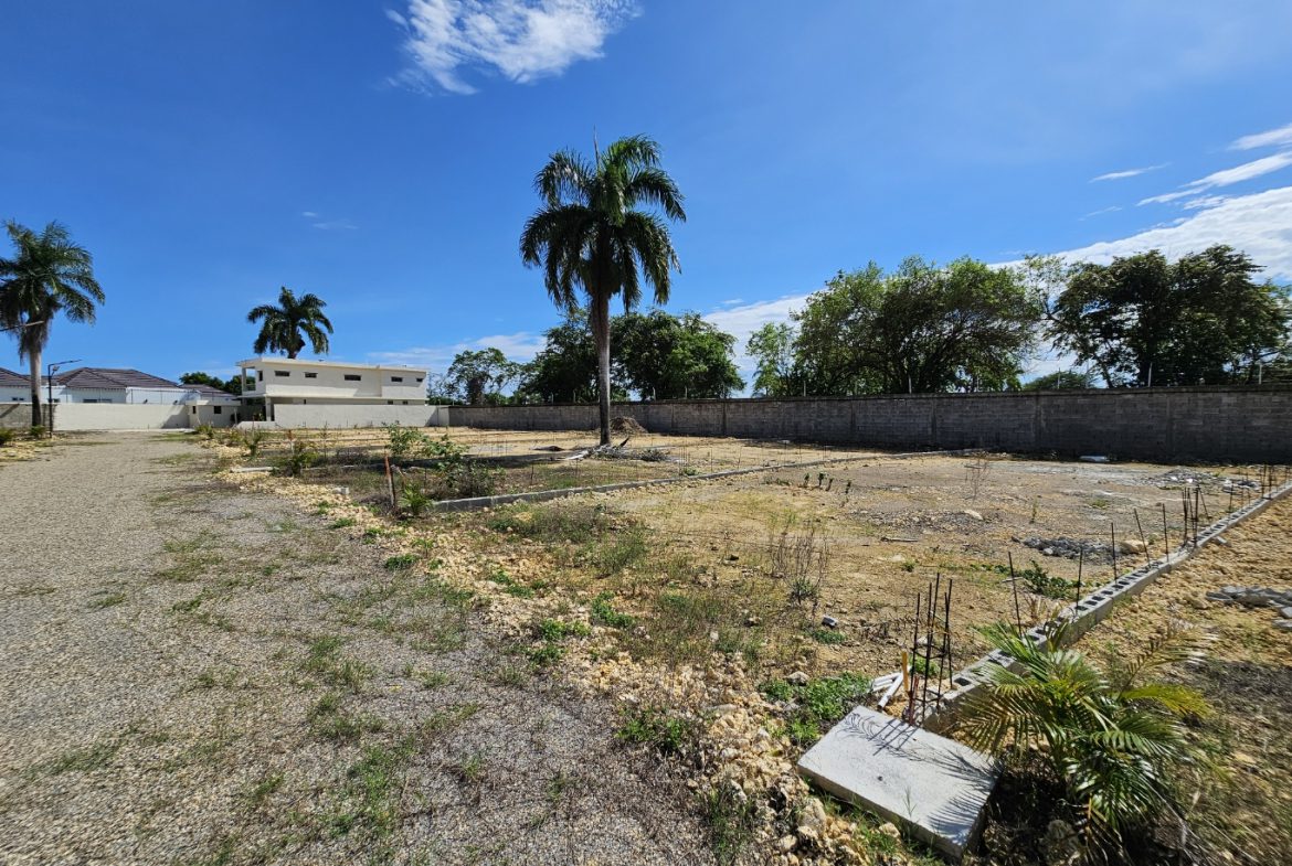 buyDRproperty Vacant land with palm trees and a wall under a blue sky. Sosua Real Estate