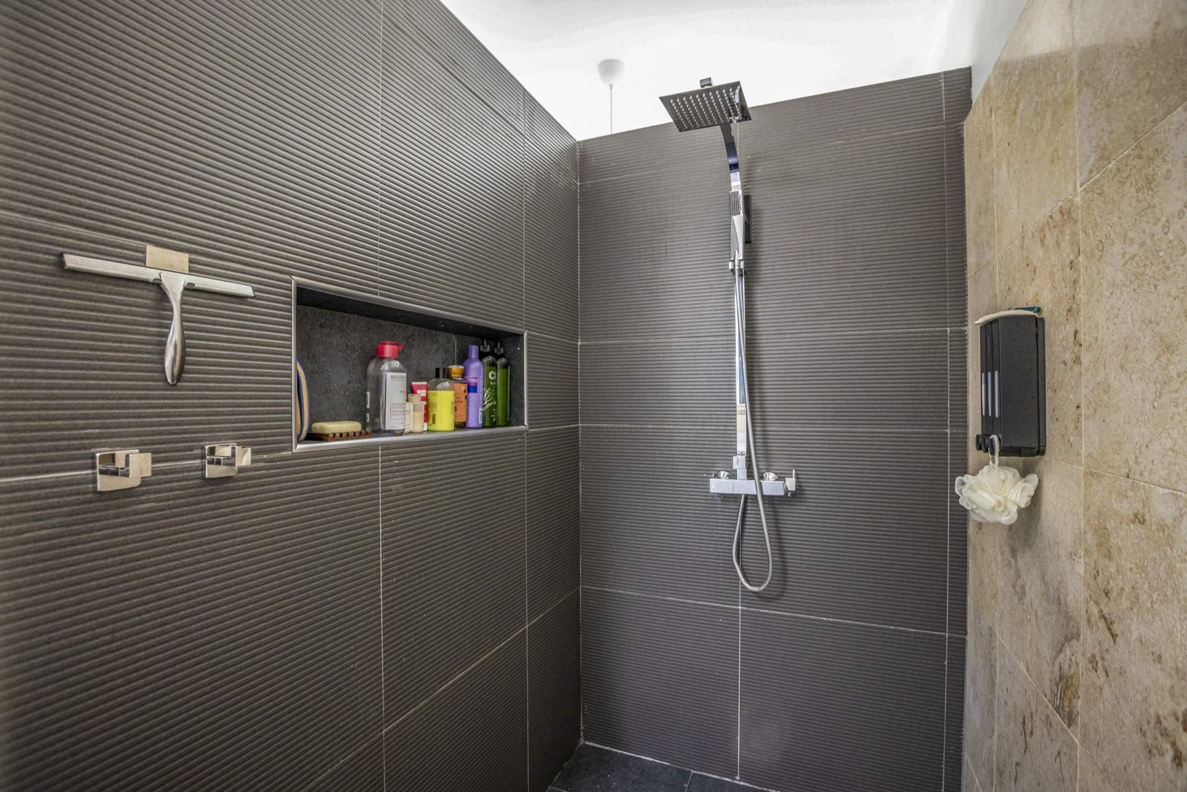 buyDRproperty Modern shower with gray tile, shower products, and a squeegee Sosua Real Estate