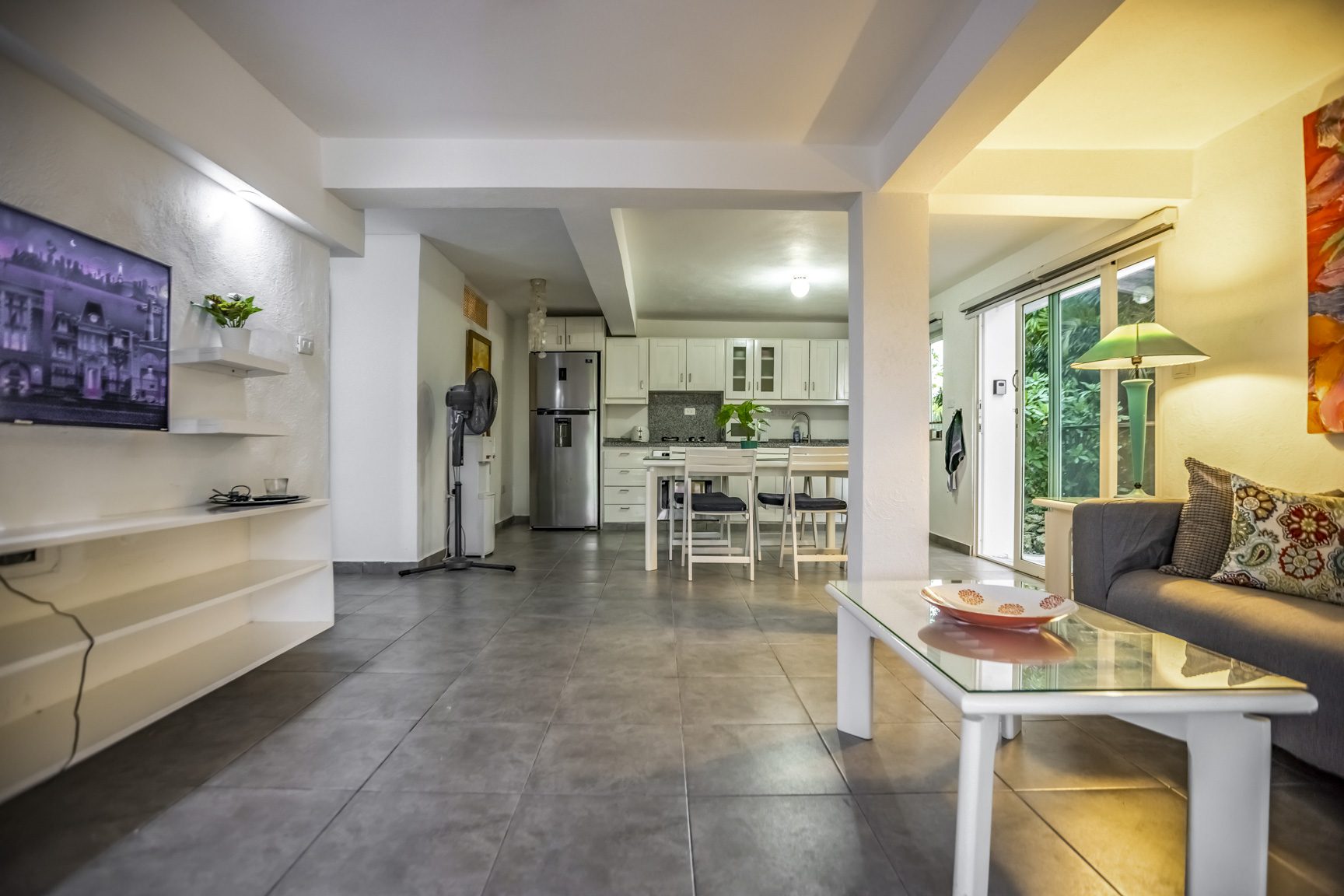 buyDRproperty Modern open living room with a TV, cozy sofa, and a view into the kitchen Sosua Real Estate