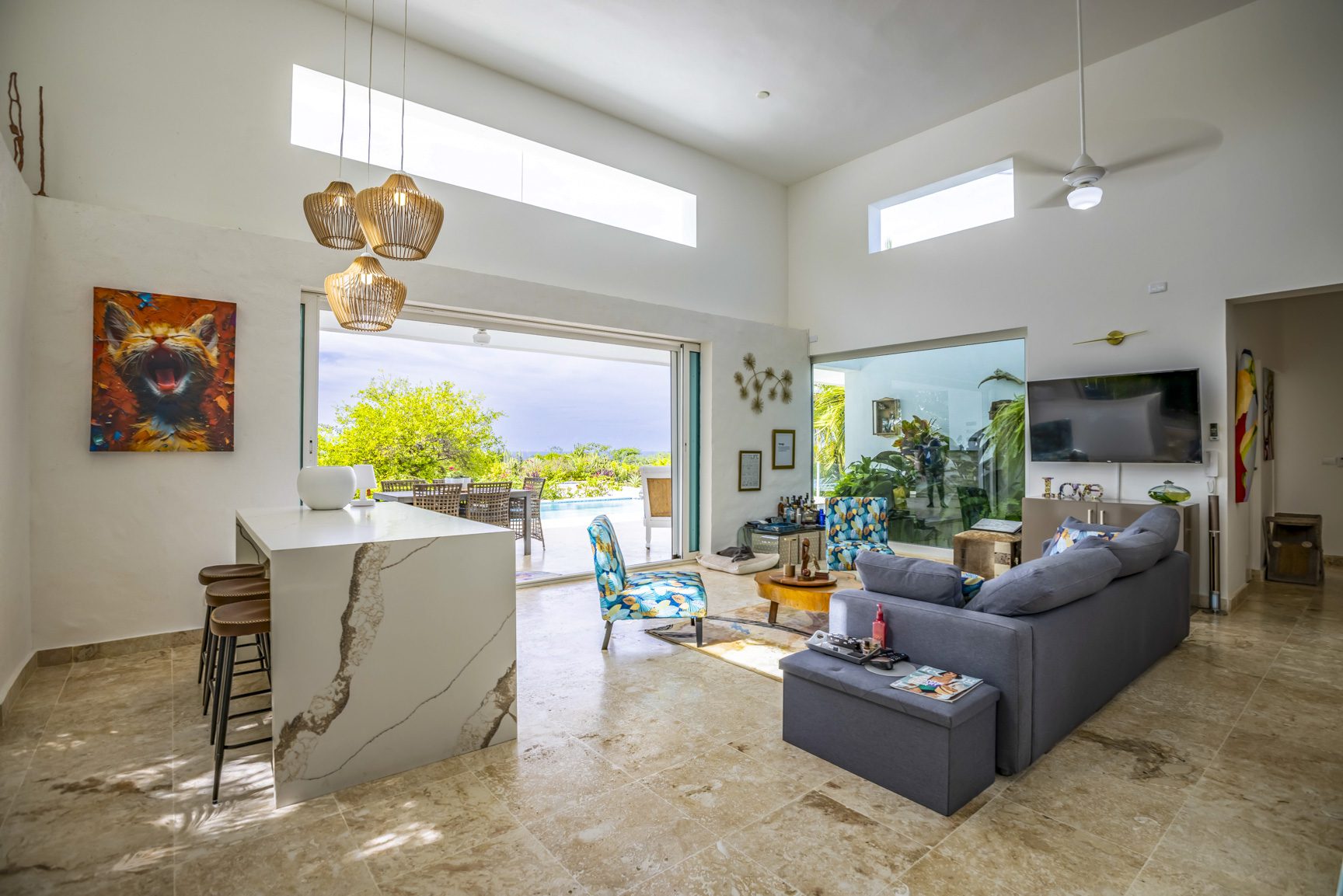 buyDRproperty Bright, modern living room with pool view through open sliding doors. Sosua Real Estate