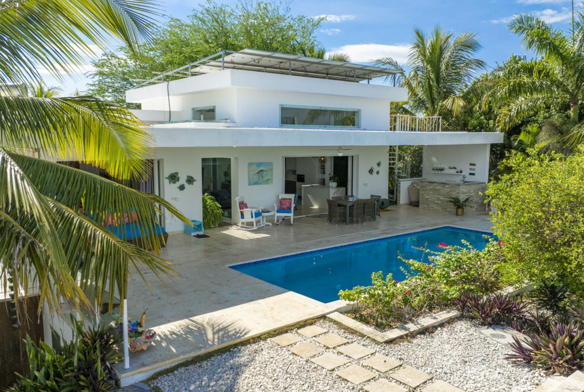 buyDRproperty Modern white villa with pool, palm trees, and solar panels Sosua Real Estate