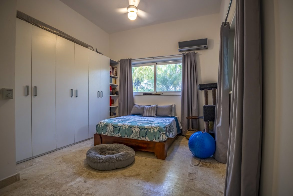 buyDRproperty Cozy small bedroom with large wardrobe, bed, and natural light. Bedroom design. Sosua Real Estate
