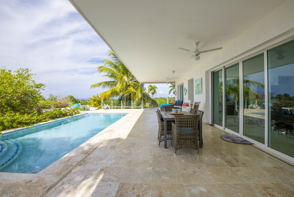 buyDRproperty Spacious patio with dining set and pool overlooking tropical landscape Sosua Real Estate
