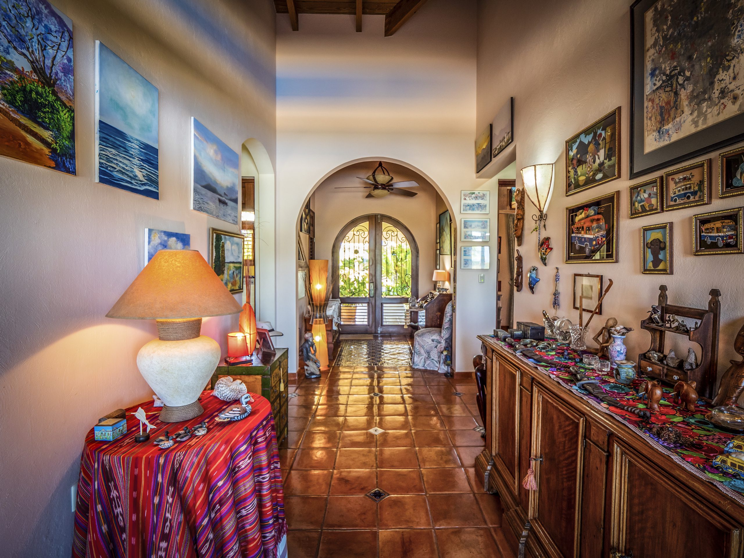 buyDRproperty Colorful art-filled hallway with wooden furniture and warm lighting Sosua Real Estate