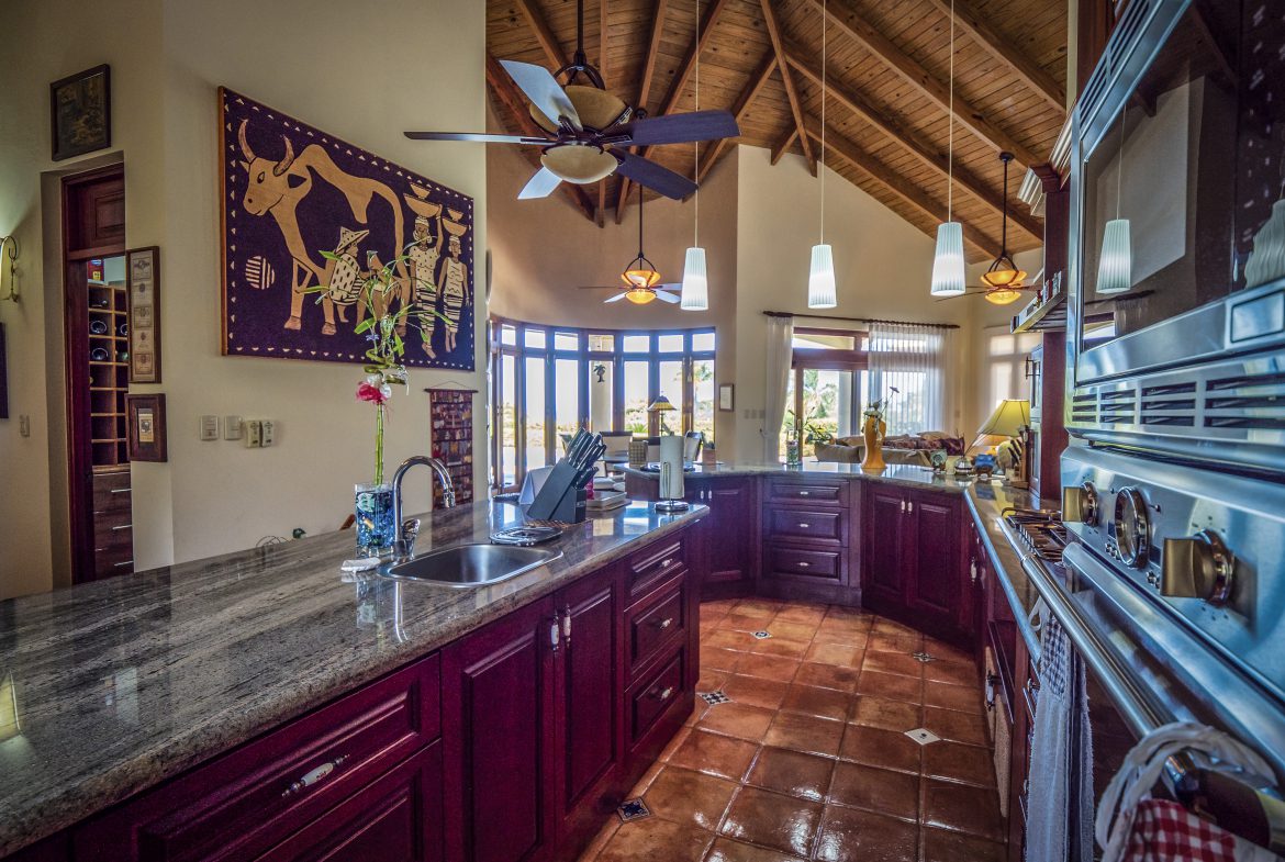 buyDRproperty Rustic kitchen with wooden ceiling, granite countertops, and pendant lights Sosua Real Estate