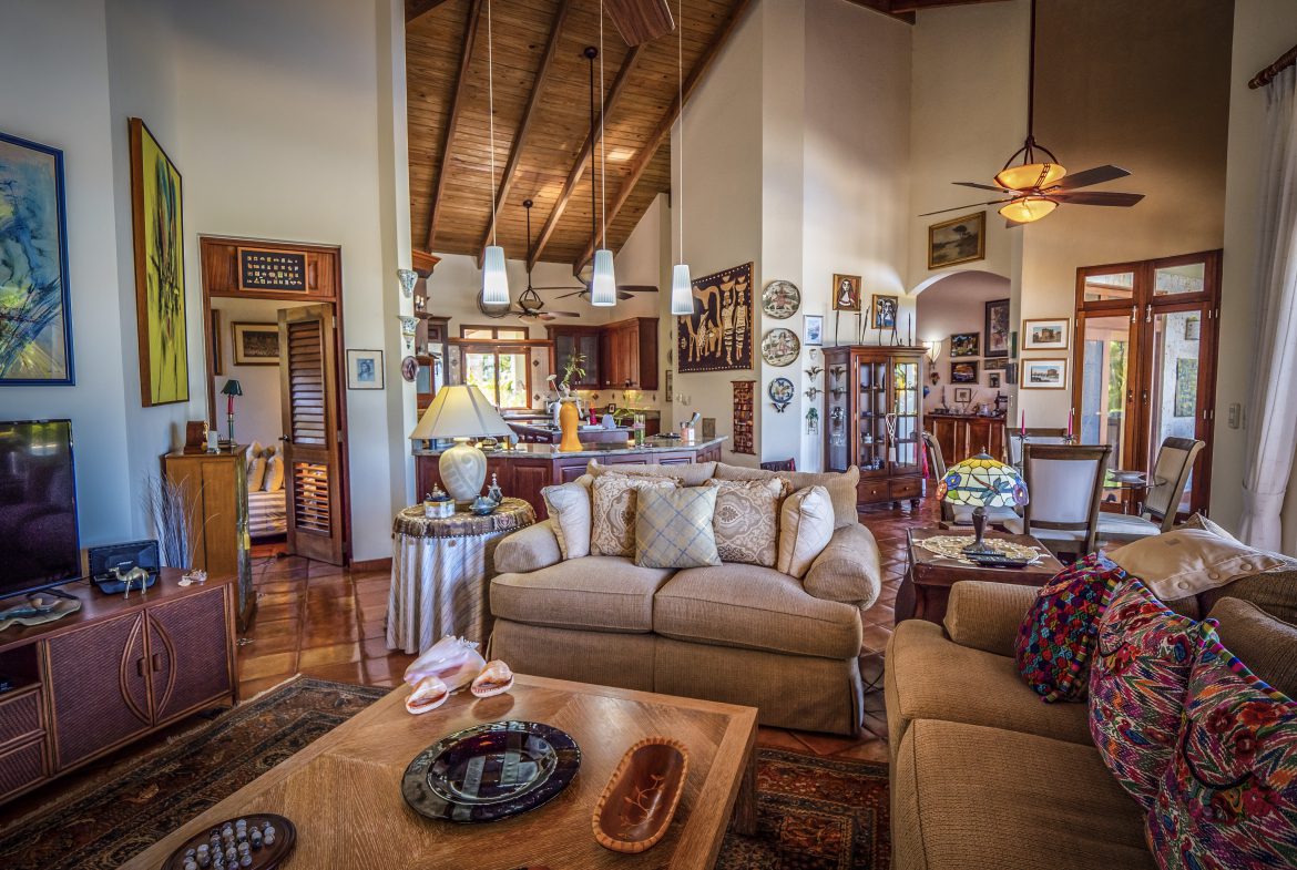 buyDRproperty Spacious living room with high wooden ceiling and cozy seating area Sosua Real Estate